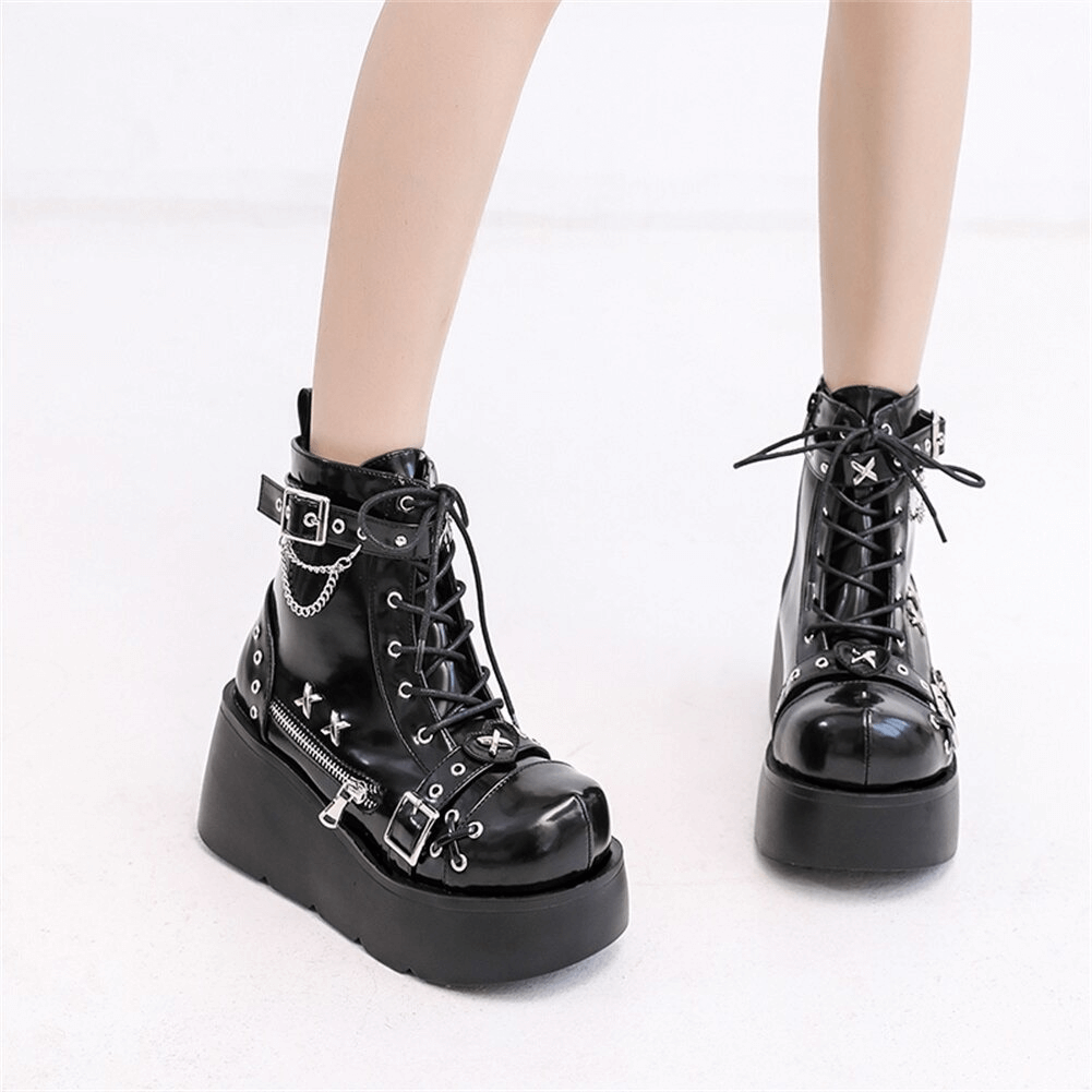 Black platform ankle boots with lace-up front and thick platform sole worn on model - front pair view