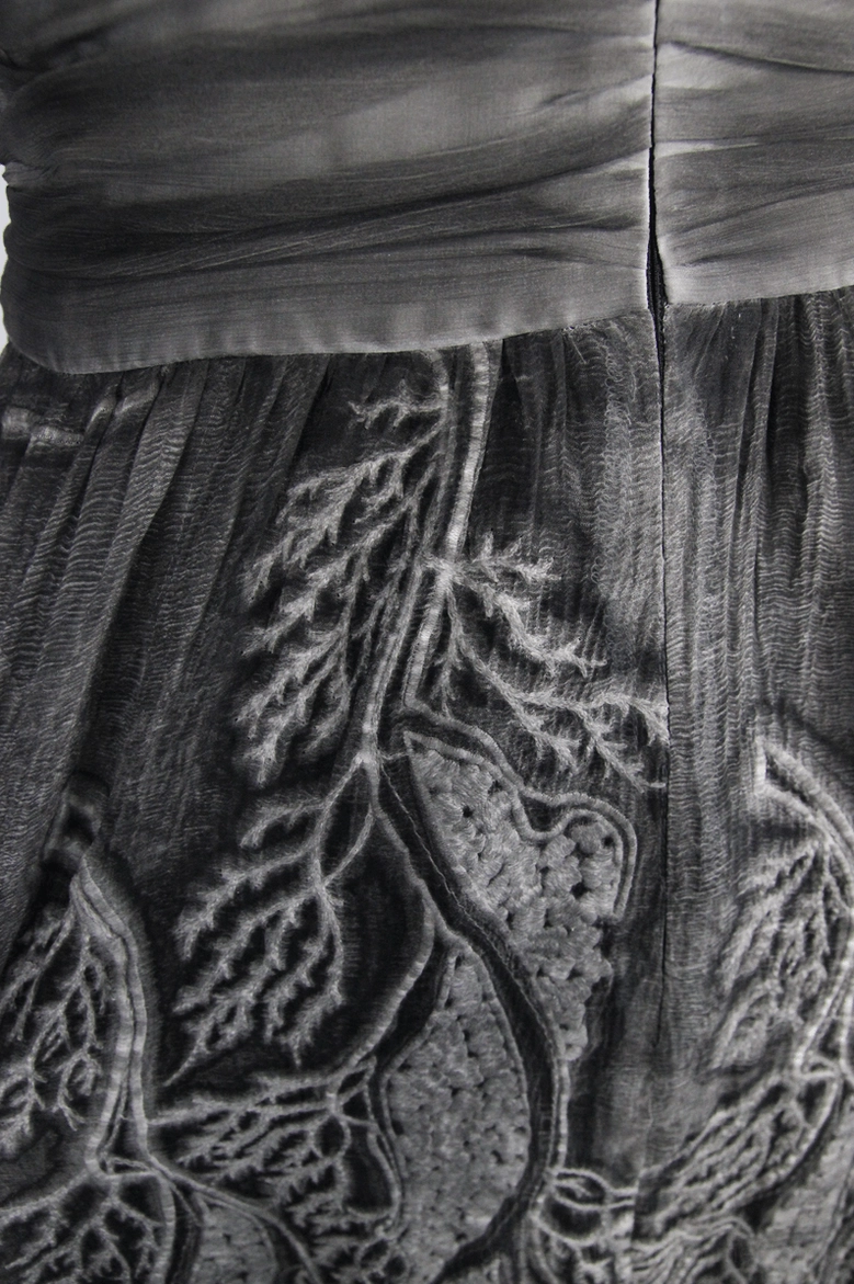 Alternative fashion grey backless dress showing full silhouette and leaf print embellishment