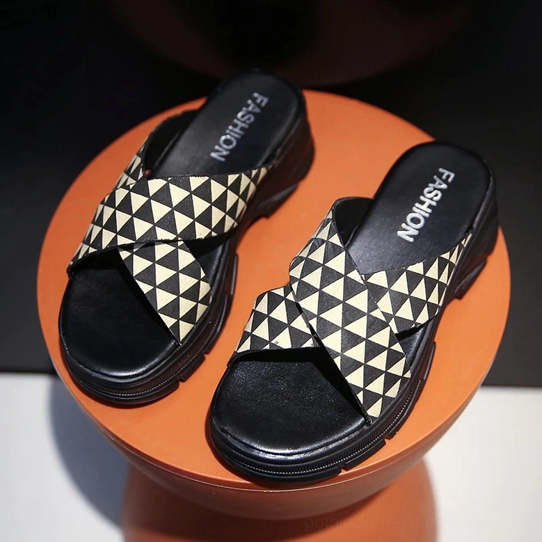 Crisscross platform sandal pair with fashion branded insole, overhead side view on terracotta display stand showing geometric pattern detail