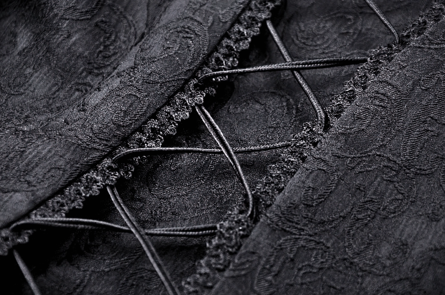 Alternative fashion black corset tailcoat detail shots highlighting structured waist and lace elements