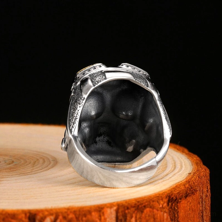 Back inner view of aviator skull ring displaying open adjustable band design on dark background with wooden base