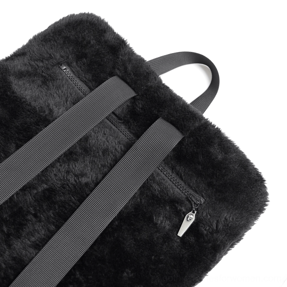Close-up detail of gothic backpack back panel showing black fluffy fabric texture, nylon shoulder straps and metal zipper puller mechanism
