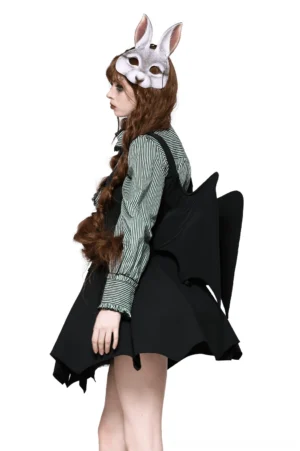 Black bat wing corset top with lace-up back worn by model with rabbit mask, styled with striped blouse and gothic accessories