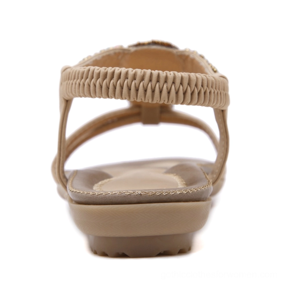 Beige beaded gothic sandal showing woven elastic ankle strap and flat rubber sole, rear top view