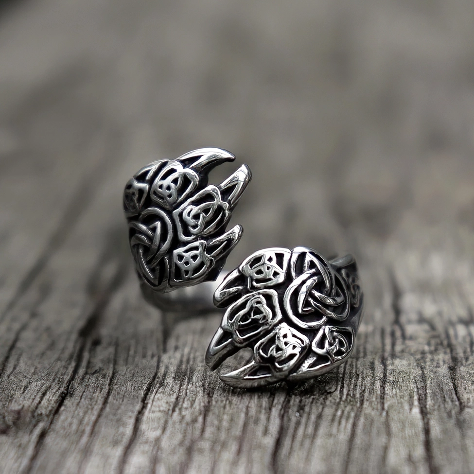 Bear claw wrap ring with Triquetra knot engravings on wooden surface, vintage silver stainless steel