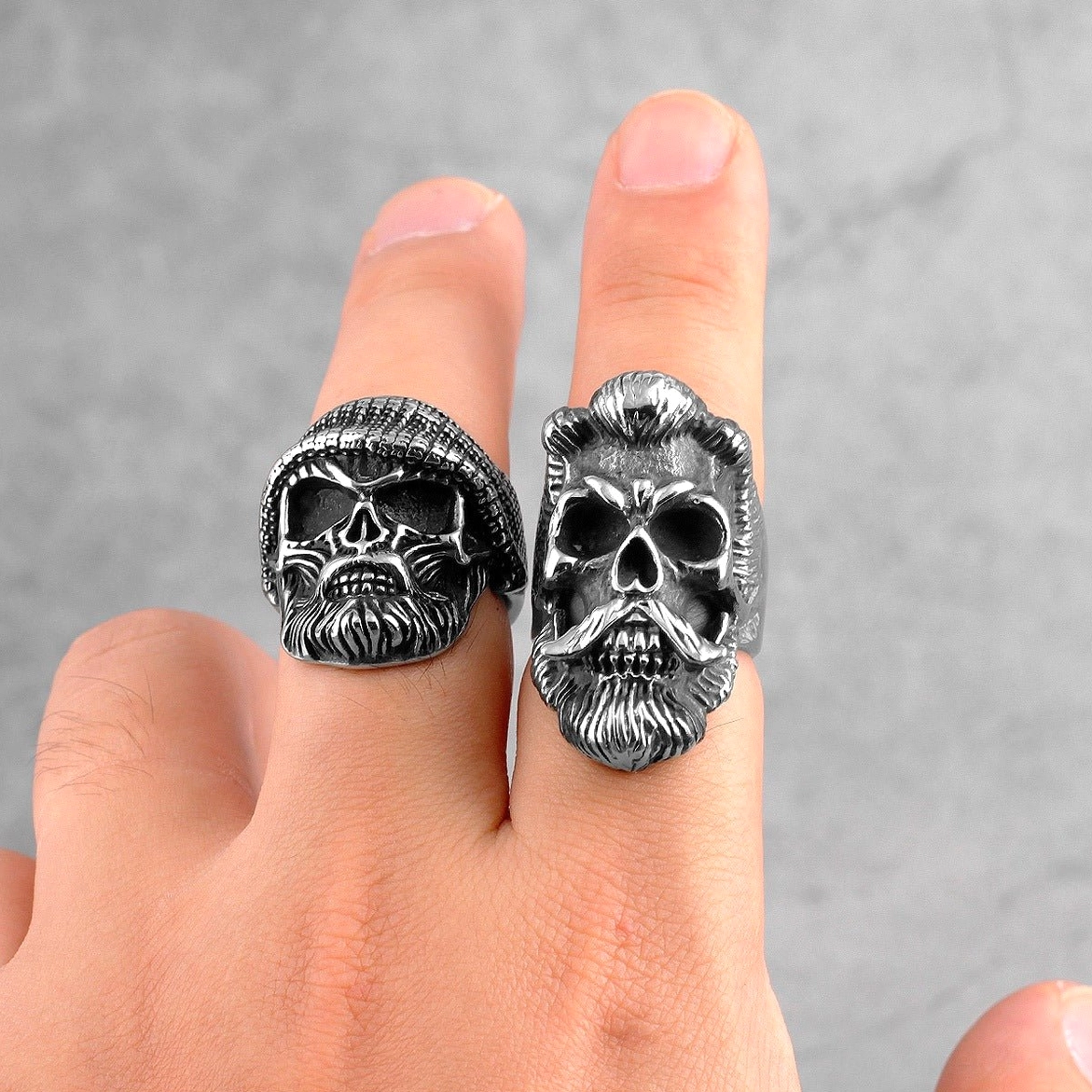 Two bearded gentleman gothic skull rings displayed on human hand showing one with knit hat beanie detail