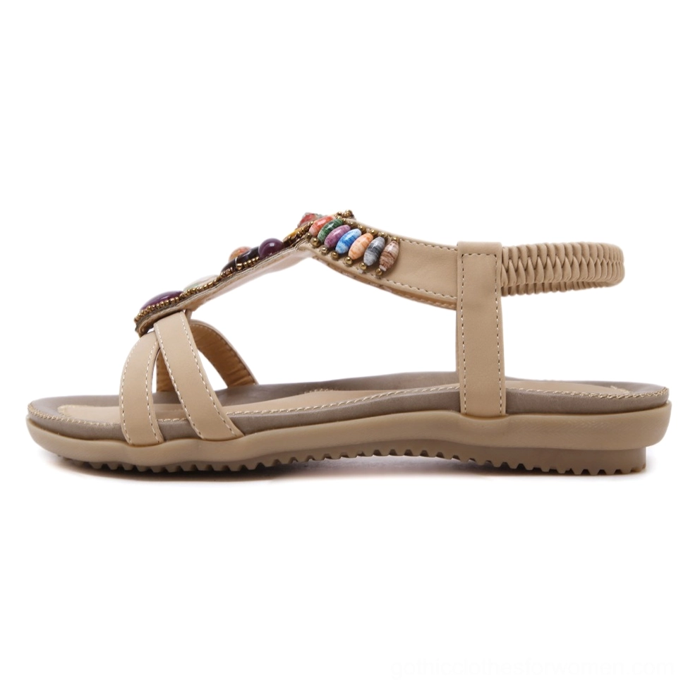 Beige PU leather beaded sandal with gemstone embellishment and elastic ankle strap, side profile view on white background