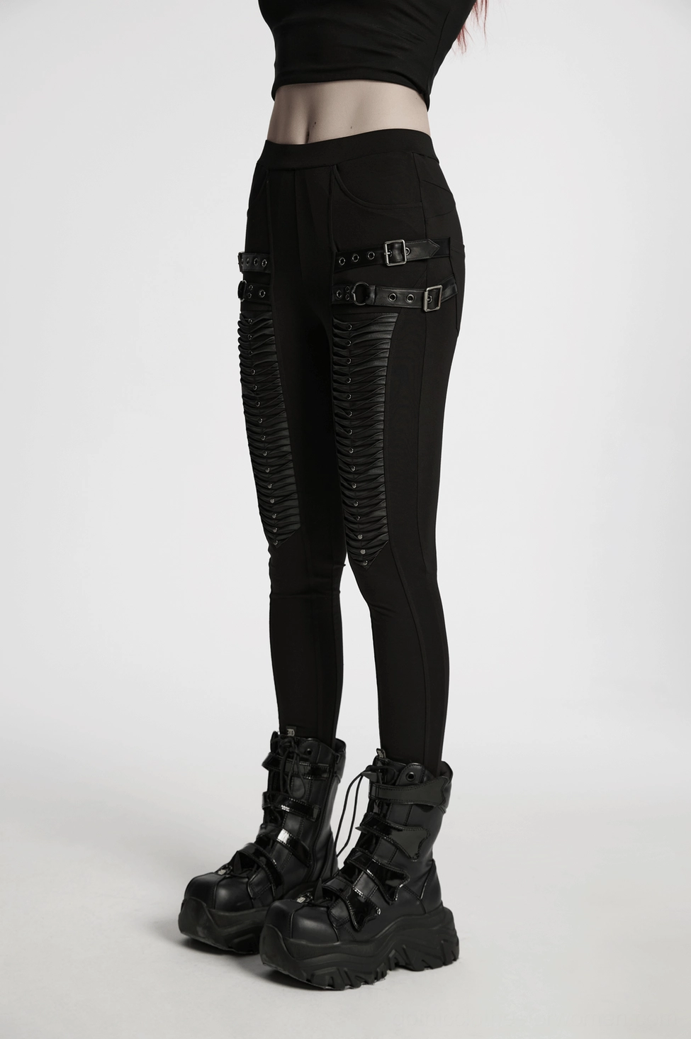 Full-length model view of black 3D pleated gothic leggings with platform boots styling