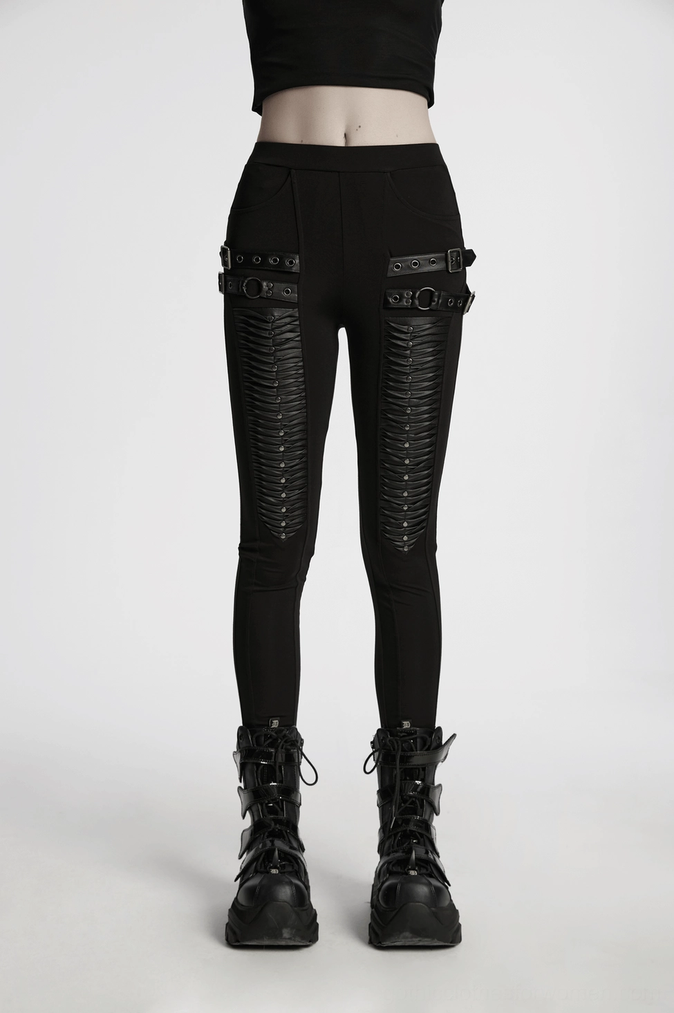 Macro view of metal studs and faux leather pleated trim on gothic leggings waist