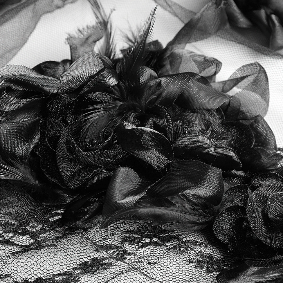 Detailed overhead view of black 3D roses and feather accents on lace veil ornament