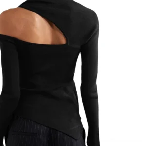 Black cold shoulder long sleeve top back view on model, displaying cutout shoulder design and asymmetric hem detail