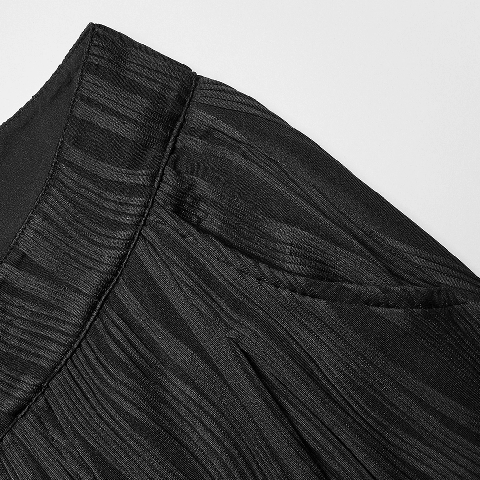Black gothic wide leg pants close-up side seam - wavy stripe texture detail and stitched garment construction on matte black fabric