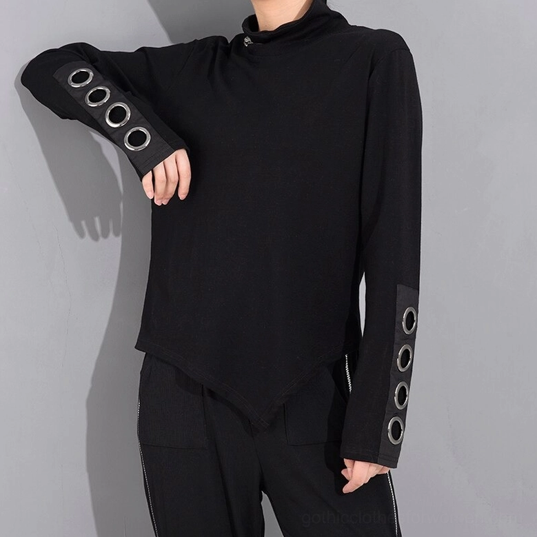 Black asymmetrical gothic top with metal grommet cuffs, casual model styling with matching black pants and platform boots