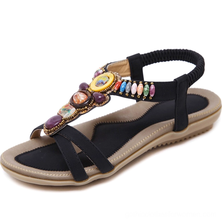 Black beaded gothic sandal with colorful gemstone decorations and elastic back strap, side oblique profile view
