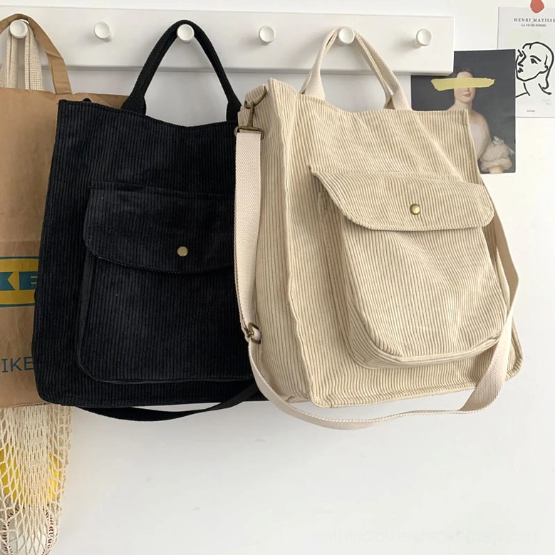 Black and beige corduroy gothic tote crossbody bags with adjustable straps, wall hook display showing shoulder and crossbody versatility