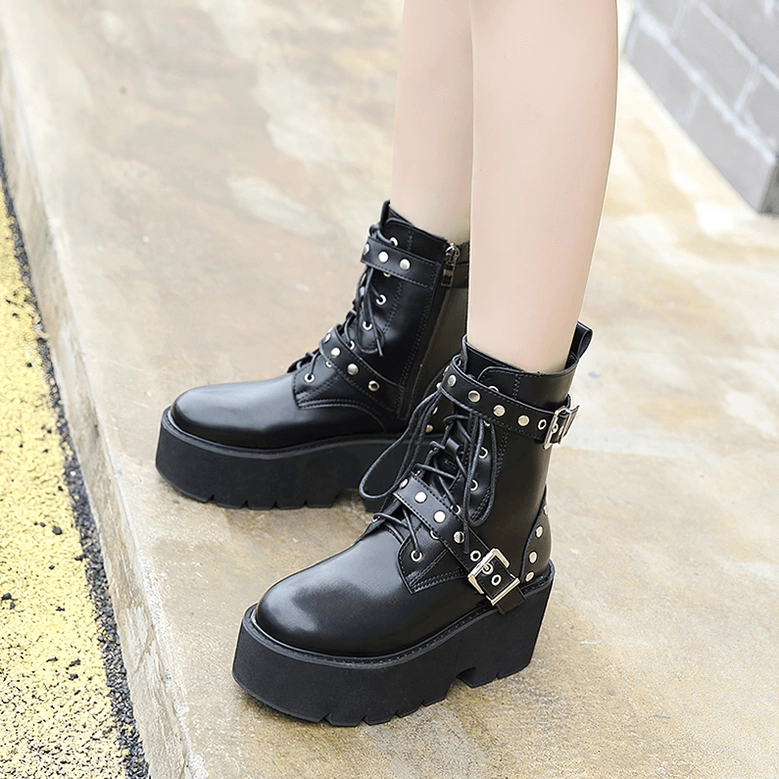 Black gothic platform combat boots styled on model, front three-quarter view showing buckle straps and rivet details