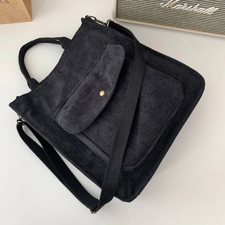 Black corduroy gothic tote bag styled in modern alternative setting with speaker, demonstrating versatile dark aesthetic carry options