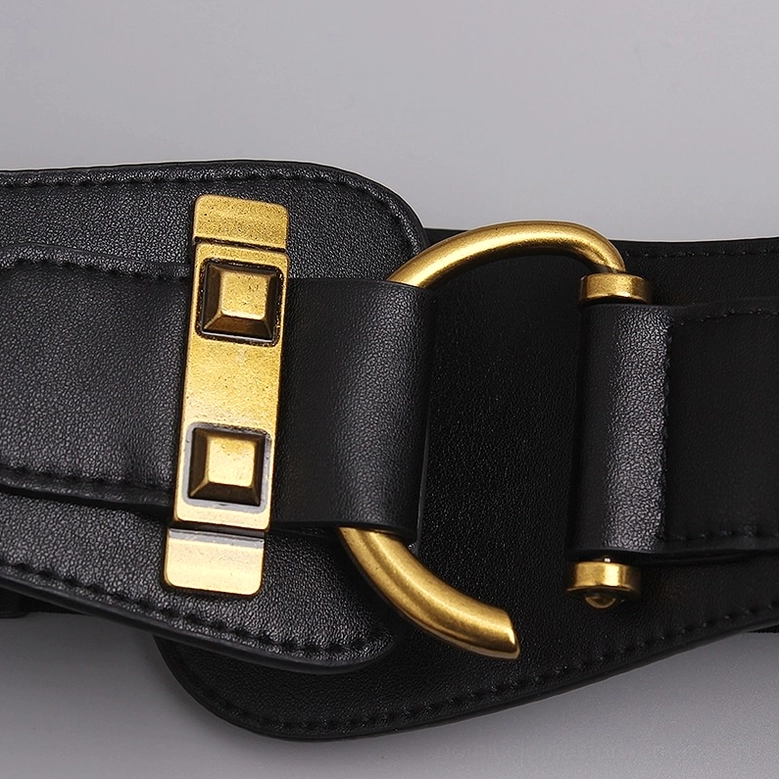 Black leather corset belt close-up detail showing smooth texture and antique gold hardware