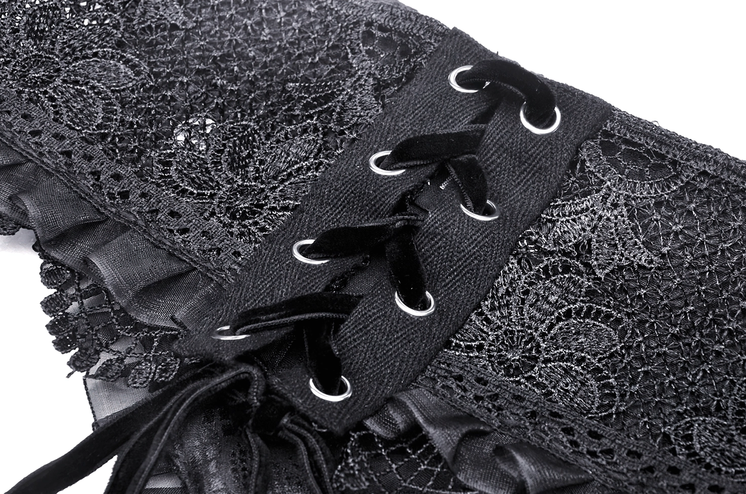 Extreme close-up macro view of black lace corset belt trim edge showing ruffled lace work and satin ribbon lacing texture