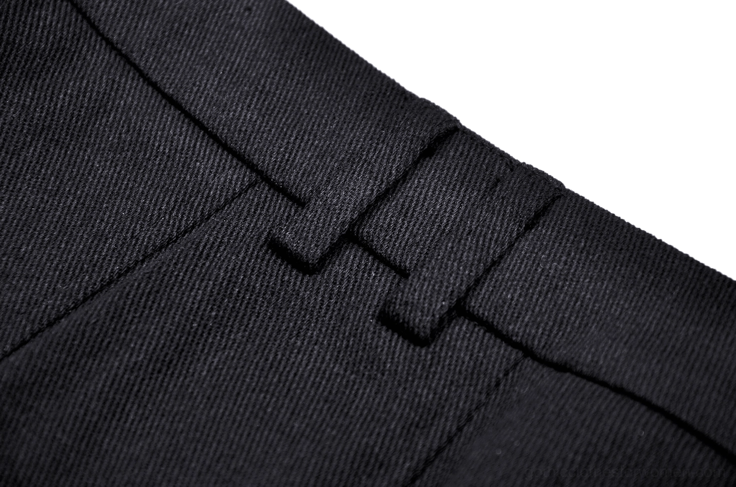 Close-up of black woven cotton fabric with knife pleat seams and stitching detail