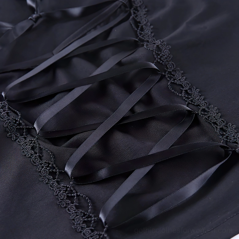 Detailed view of corset-style satin ribbon laces and embroidered floral lace trim on black gothic crop top