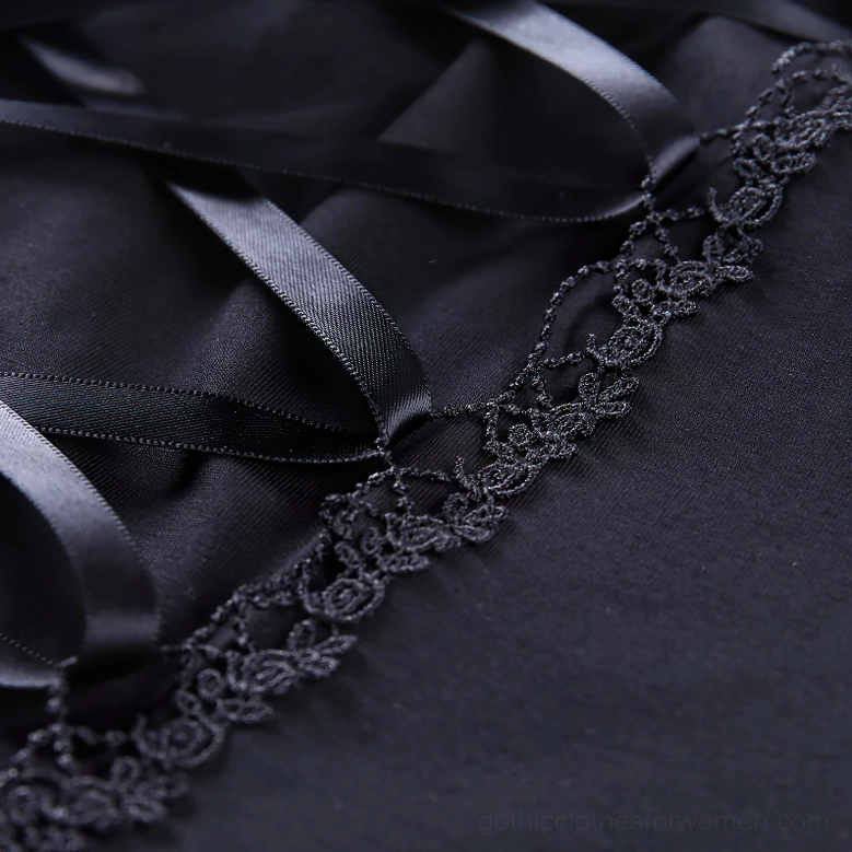 Lower lace-up detail and floral lace trim on black gothic crop top showing satin ribbon construction