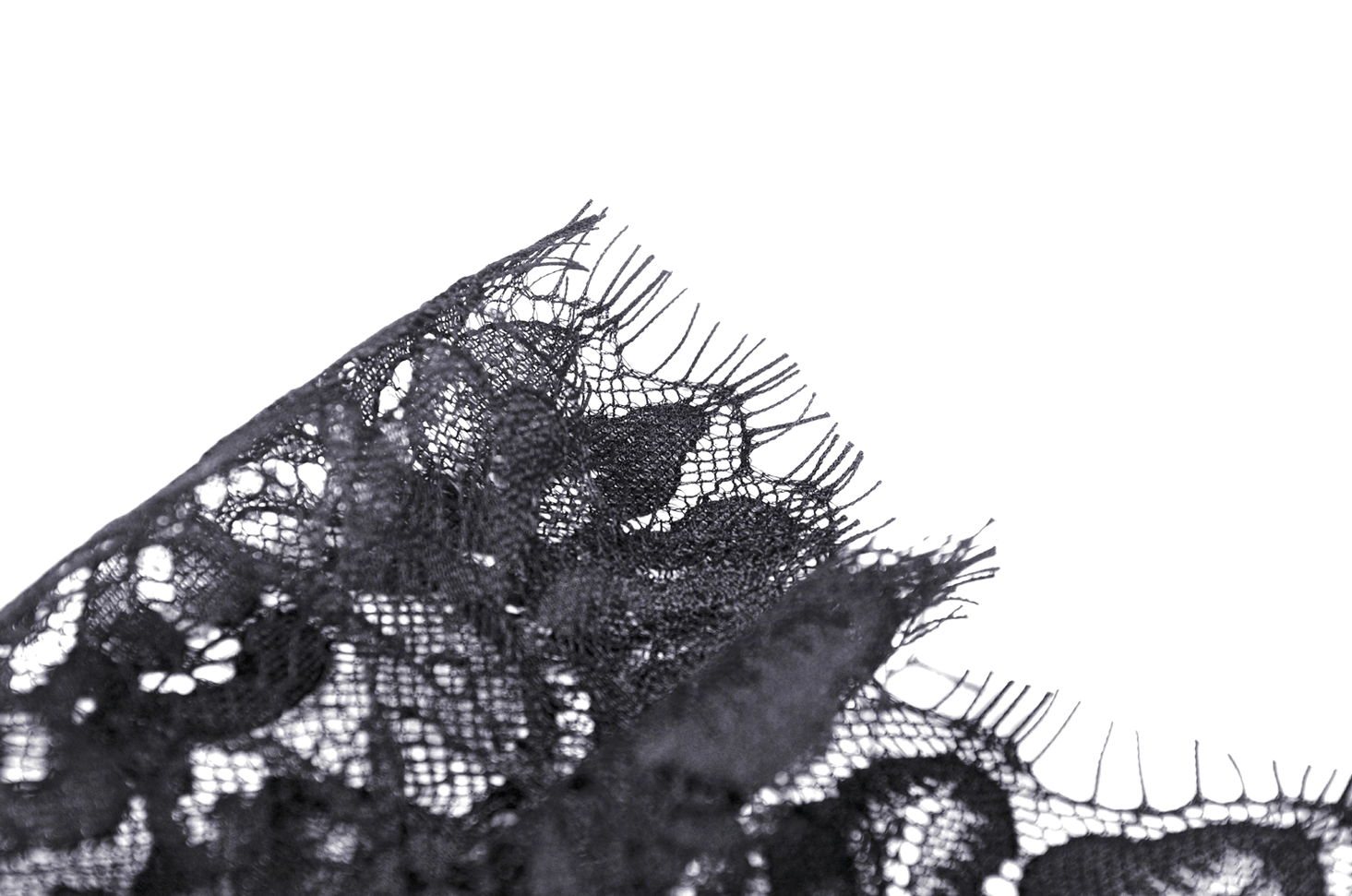 Close-up macro shot of black crushed velvet fabric texture with wrinkled shiny finish