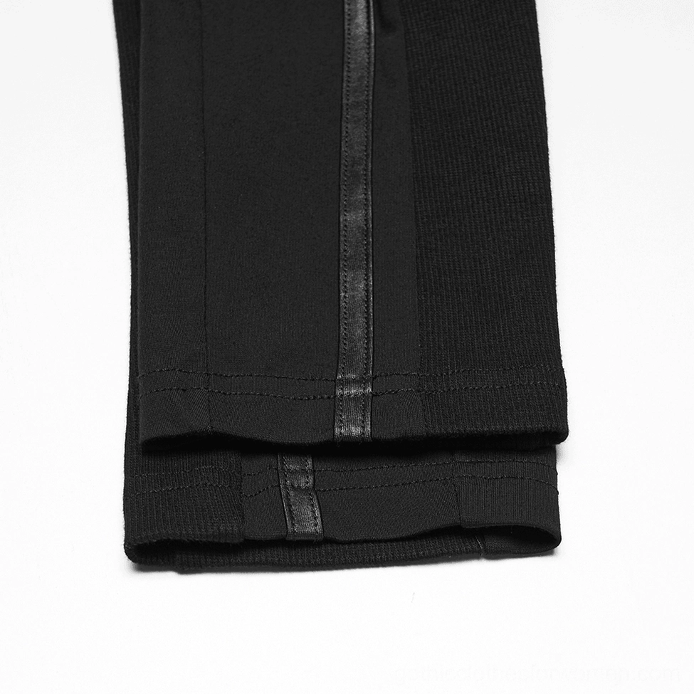 Close-up detail of black cyberpunk armor leggings hem and lower leg section showing ribbed knit fabric with leather-like stripe trim on flat lay