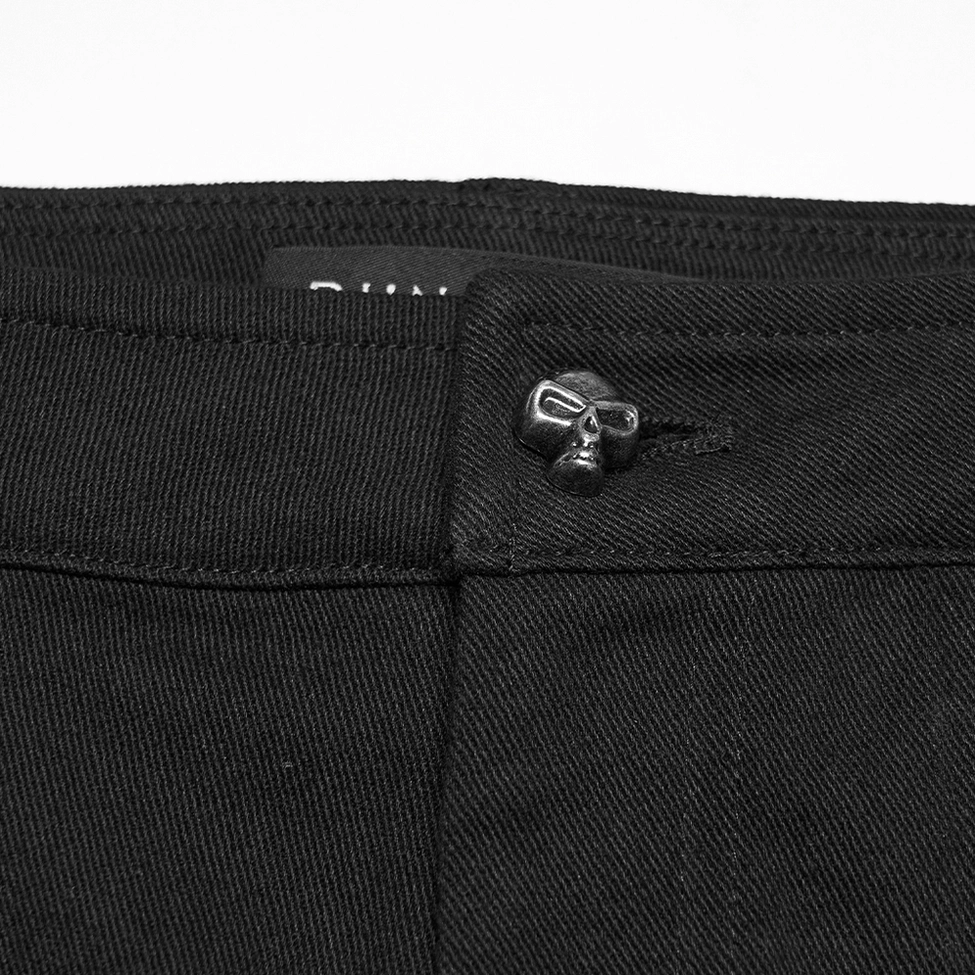 Close-up detail of skull-shaped metal button waistband on black twill denim shorts