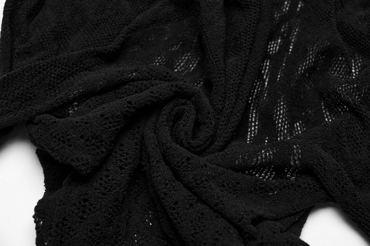 Close-up texture of black diamond knit mesh fabric showing dense stretch weave and sheer material quality