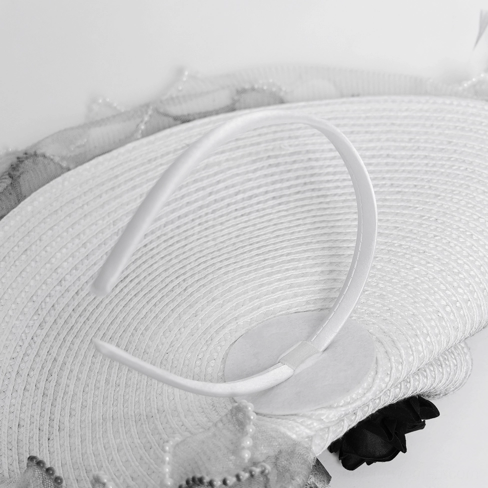 Black fascinator hat with ruffled mesh brim showing architectural definition and ethereal quality