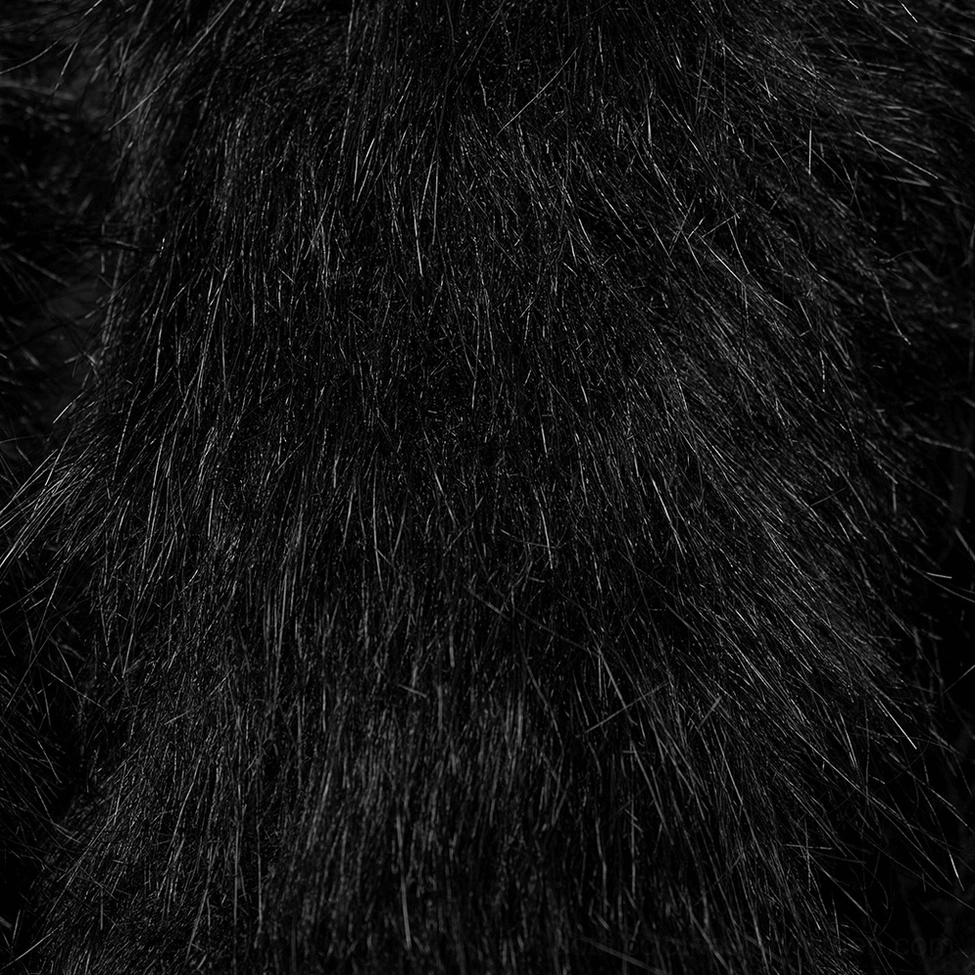 Black faux fur texture extreme close-up showing dense shaggy pile and luxurious finish