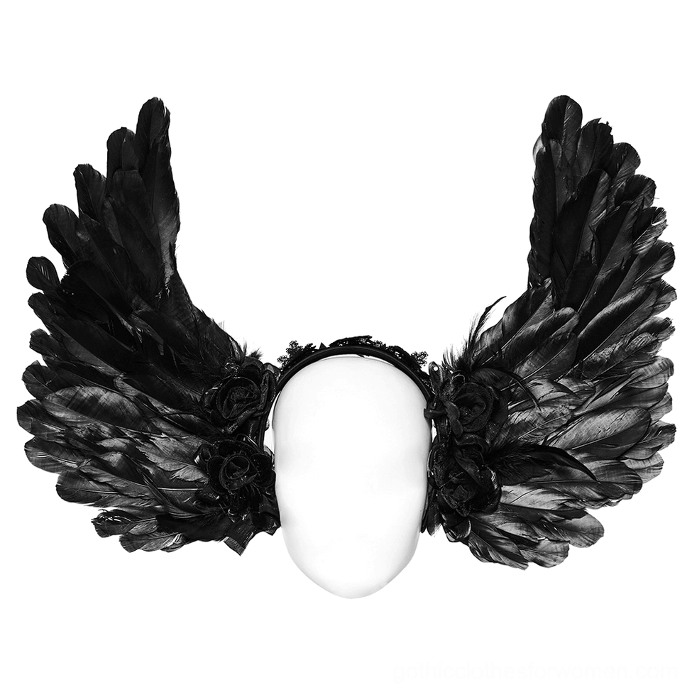 Close-up flat lay of black feather devil wings headband showing architectural wing structure with black velvet roses and spike accents