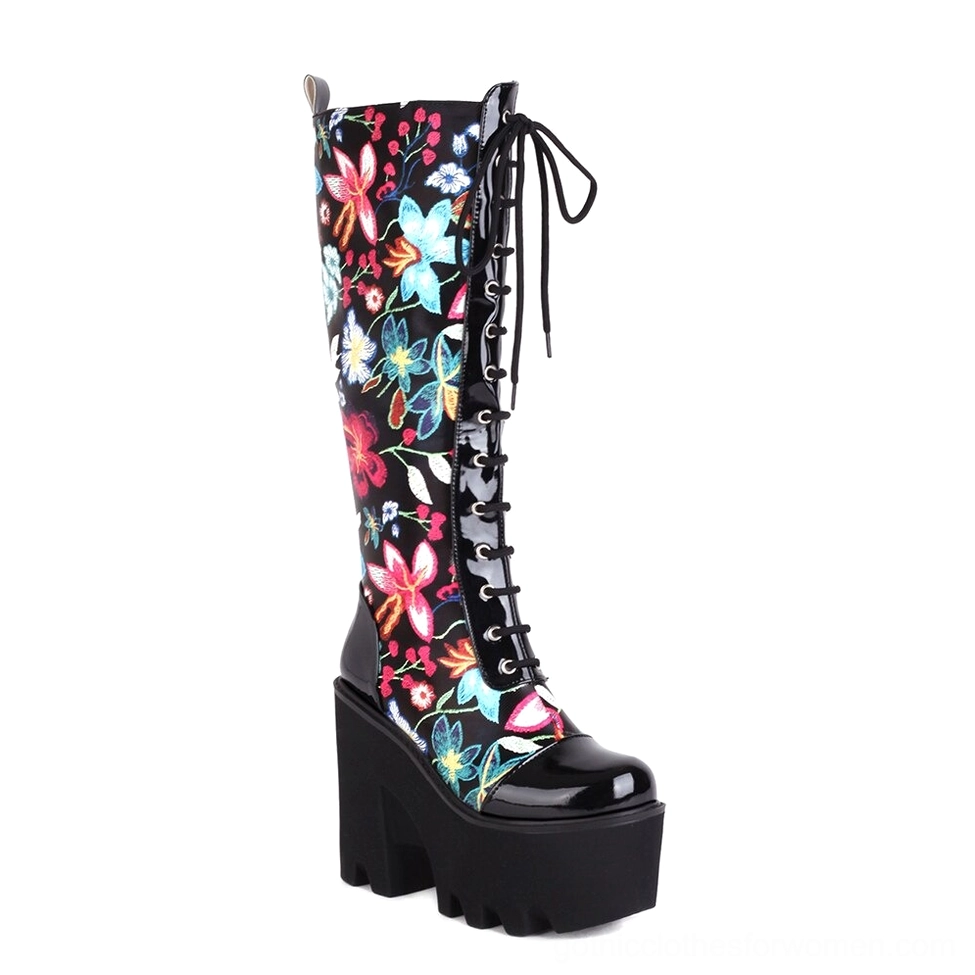 Black floral print lace-up gothic platform knee-high boots with patent leather toe cap and chunky sole, front view
