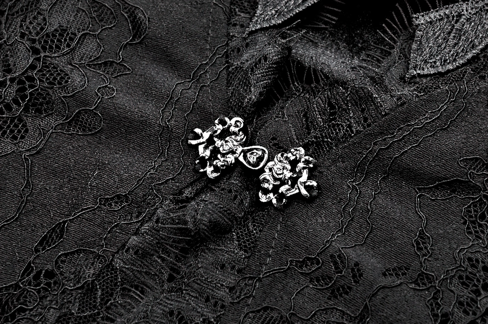 Macro detail of black floral lace fabric texture and metal decorative hardware