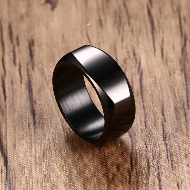 Black geometric stainless steel gothic band ring with high polished finish on wooden surface