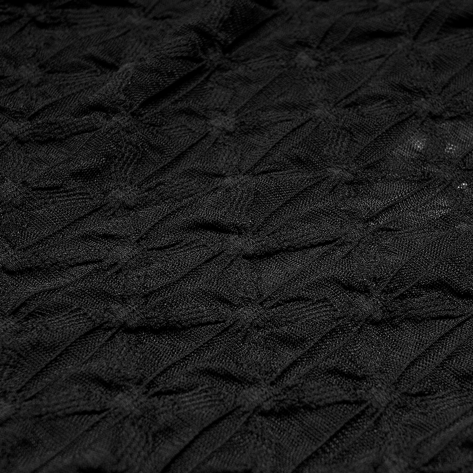 Black geometric spiderweb lace fabric close-up of gothic crop top, showing translucent lightweight textile and repeating pattern detail