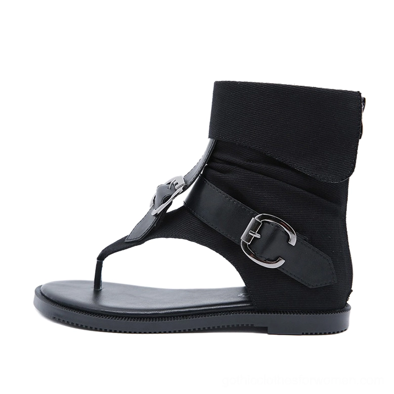 Black gladiator thong ankle sandals left side profile featuring multiple silver decorative buckles, fold-over ankle cuff, and flat sole