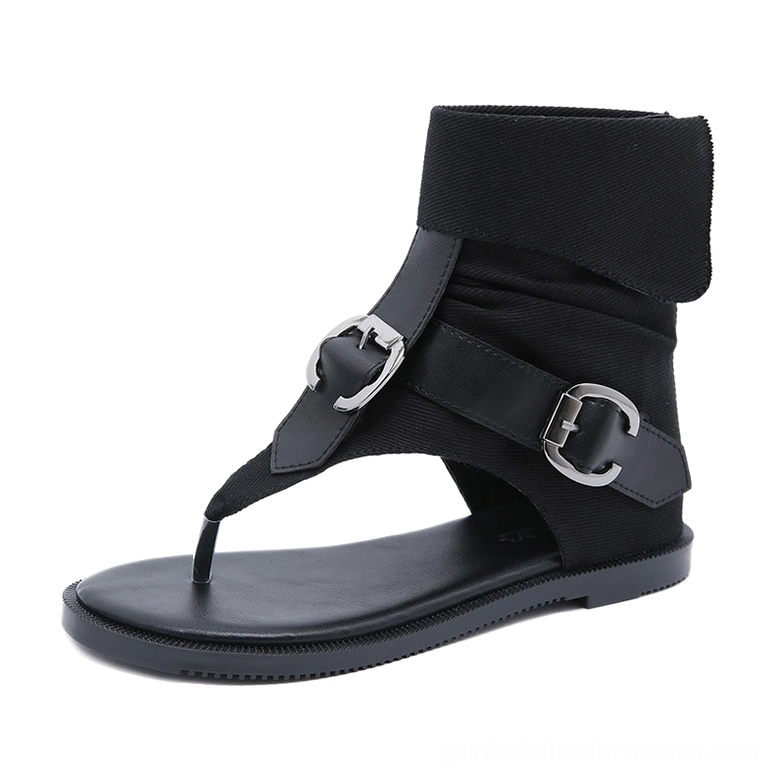 Single black gladiator flip flop sandal right side profile showing silver buckles, flat rubber sole, and fold-over fabric cuff