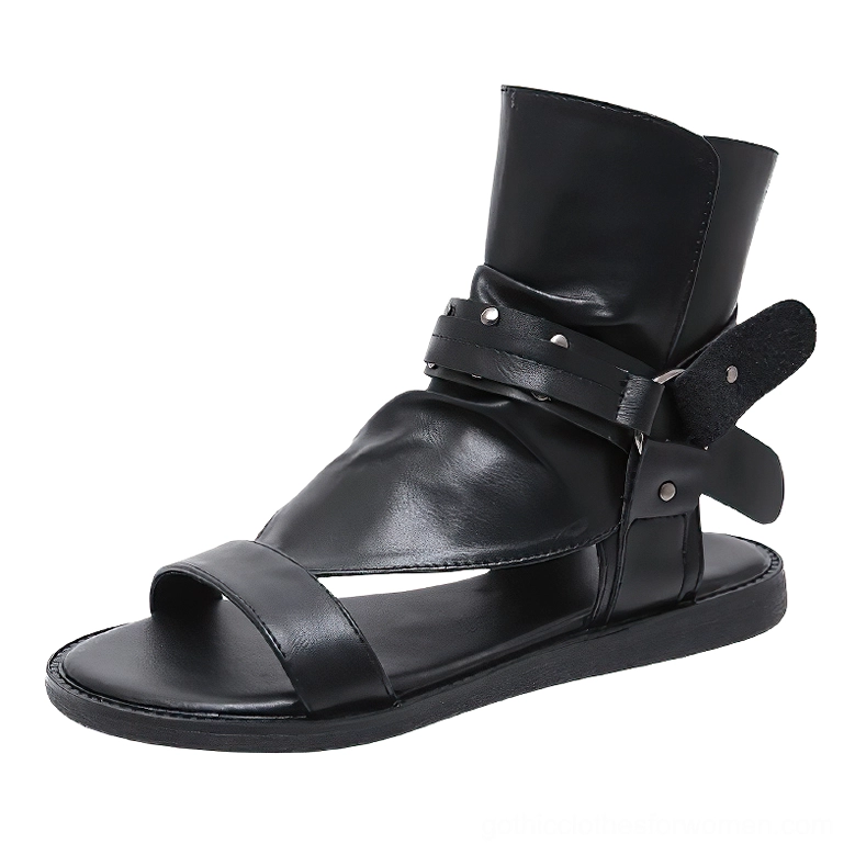 Single black gladiator sandal side profile displaying velcro buckle strap with industrial rivets and smooth leather construction