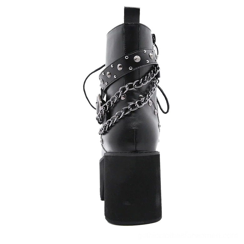 Rear view of black gothic platform ankle boot displaying back heel pull tab and wrapped chain strap design on white background