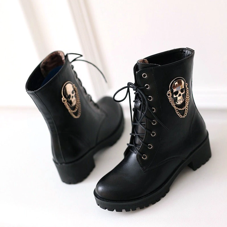 Oblique angle of black ankle boots showcasing matte finish, skull chain ornament, and square heel construction