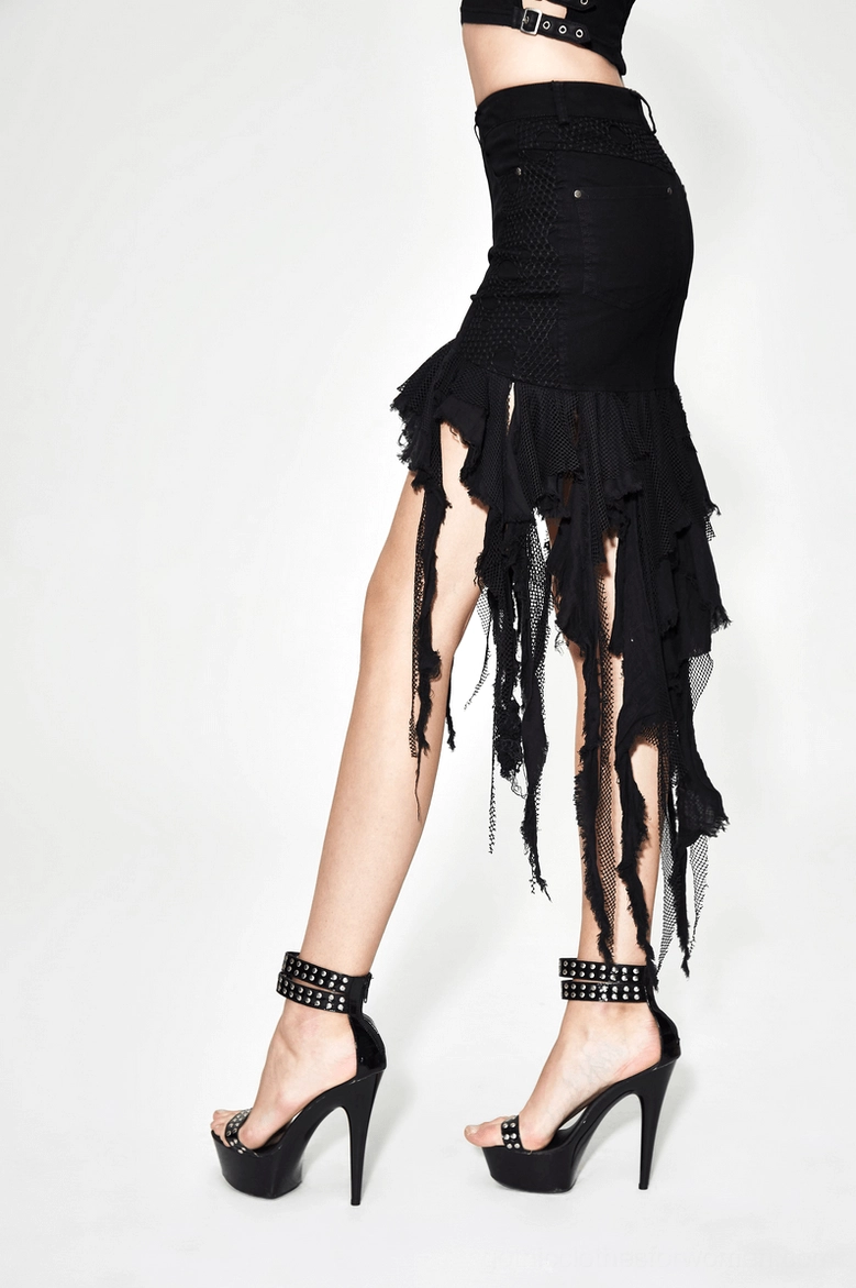 Black asymmetrical gothic denim skirt side full-body view - worn with platform heels and studded accessories