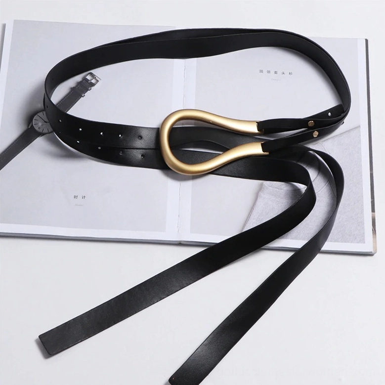 Black gothic belt with gold buckle arranged on fashion magazine flat lay, paired with luxury watch accessory for editorial styling inspiration