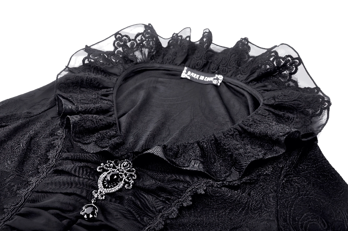 Ornamental silver filigree brooch with black gemstone pendant detail worn on black Victorian gothic blouse ruched bodice, showcasing decorative accent