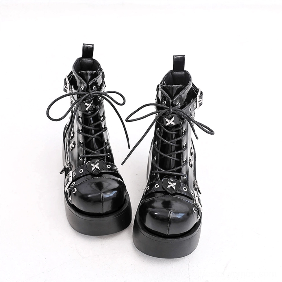 Black platform ankle boots flat lay view showing cross-shaped silver hardware and thick platform sole