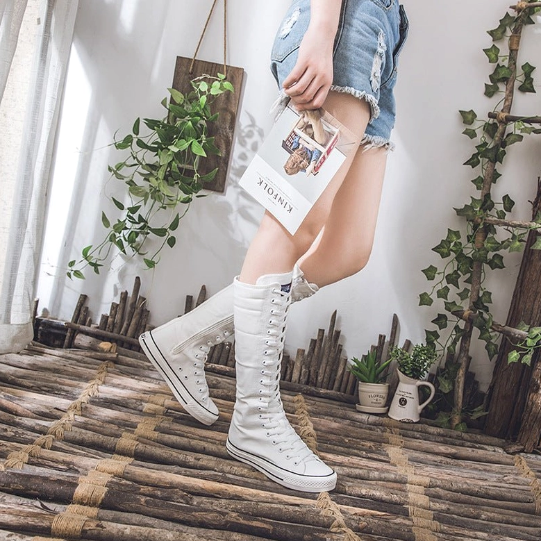 Black canvas knee-high boots detailed view of rubber outsole and construction