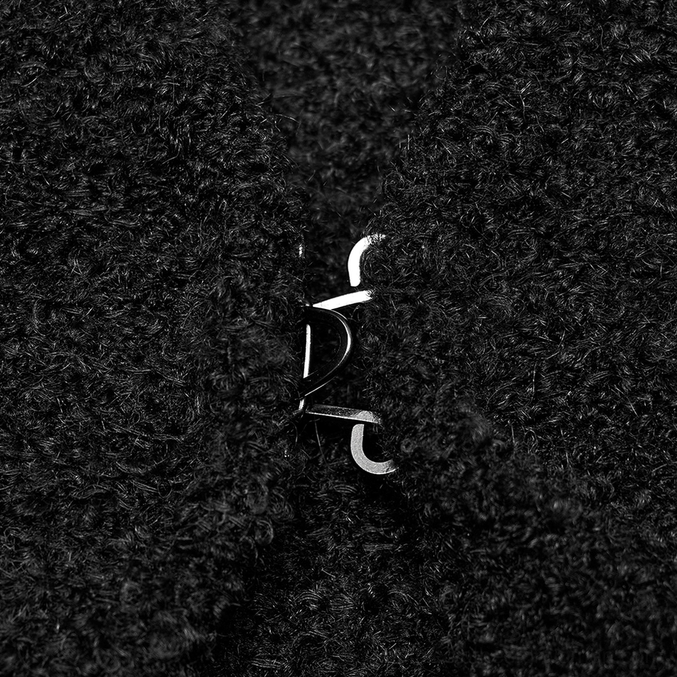 Close-up of black boucle knit fabric texture on gothic cardigan with metal hook-and-eye cuff fastener