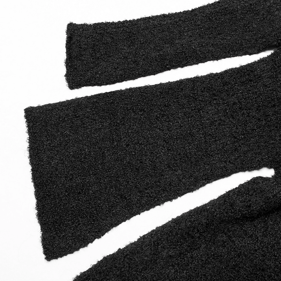 Close-up of black boucle knit asymmetric side slit hem construction on gothic cardigan