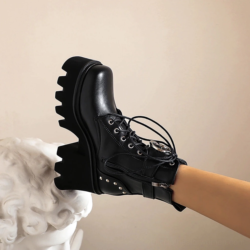 Single black gothic platform combat boot with studded metal accents and side zipper, studio indoor view showcasing edgy hardware